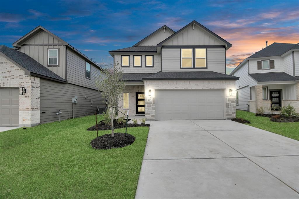 a front view of a house with a yard and garage