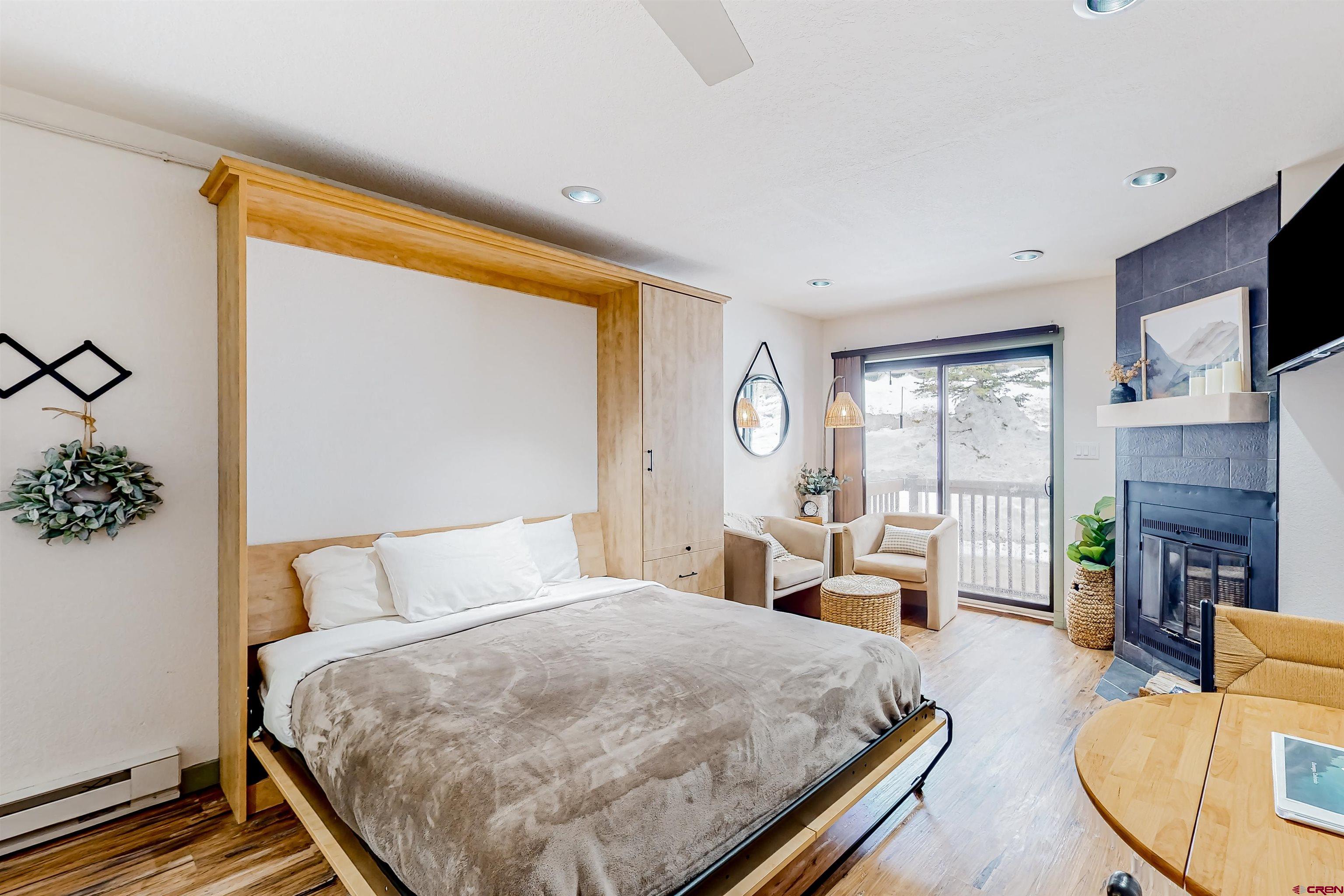 a bedroom with a bed a flat screen tv and balcony view