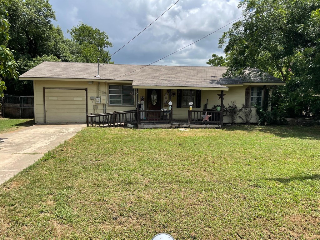 a front view of house with yard and trees in the background