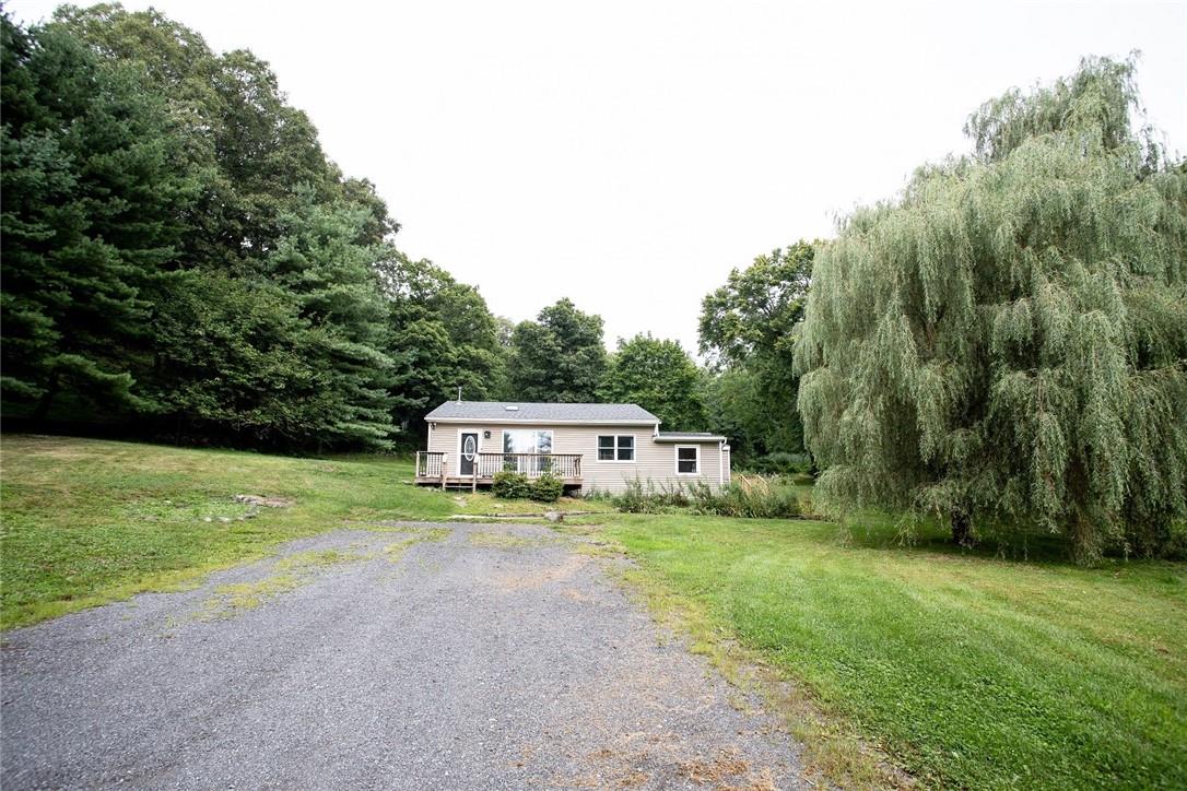 View of front facade featuring a deck and a front lawn