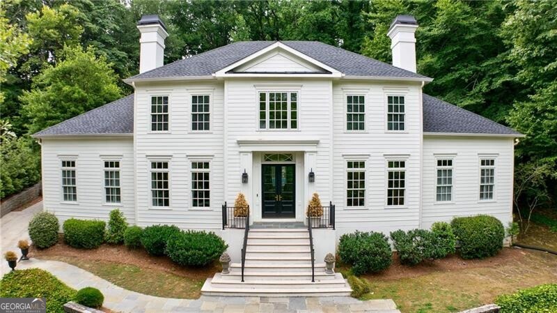 a white house with a yard and potted plants