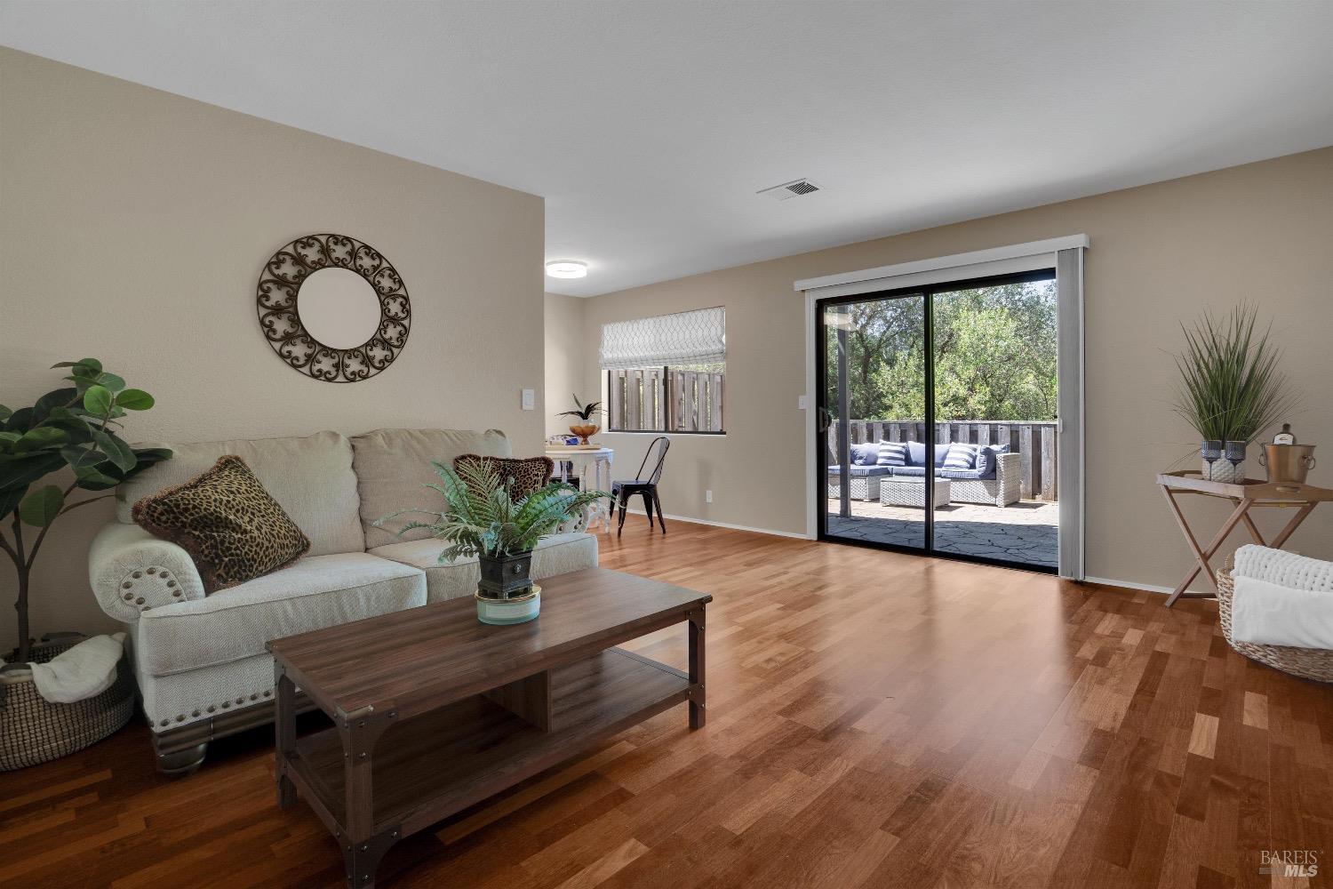 a living room with furniture a large window and wooden floor