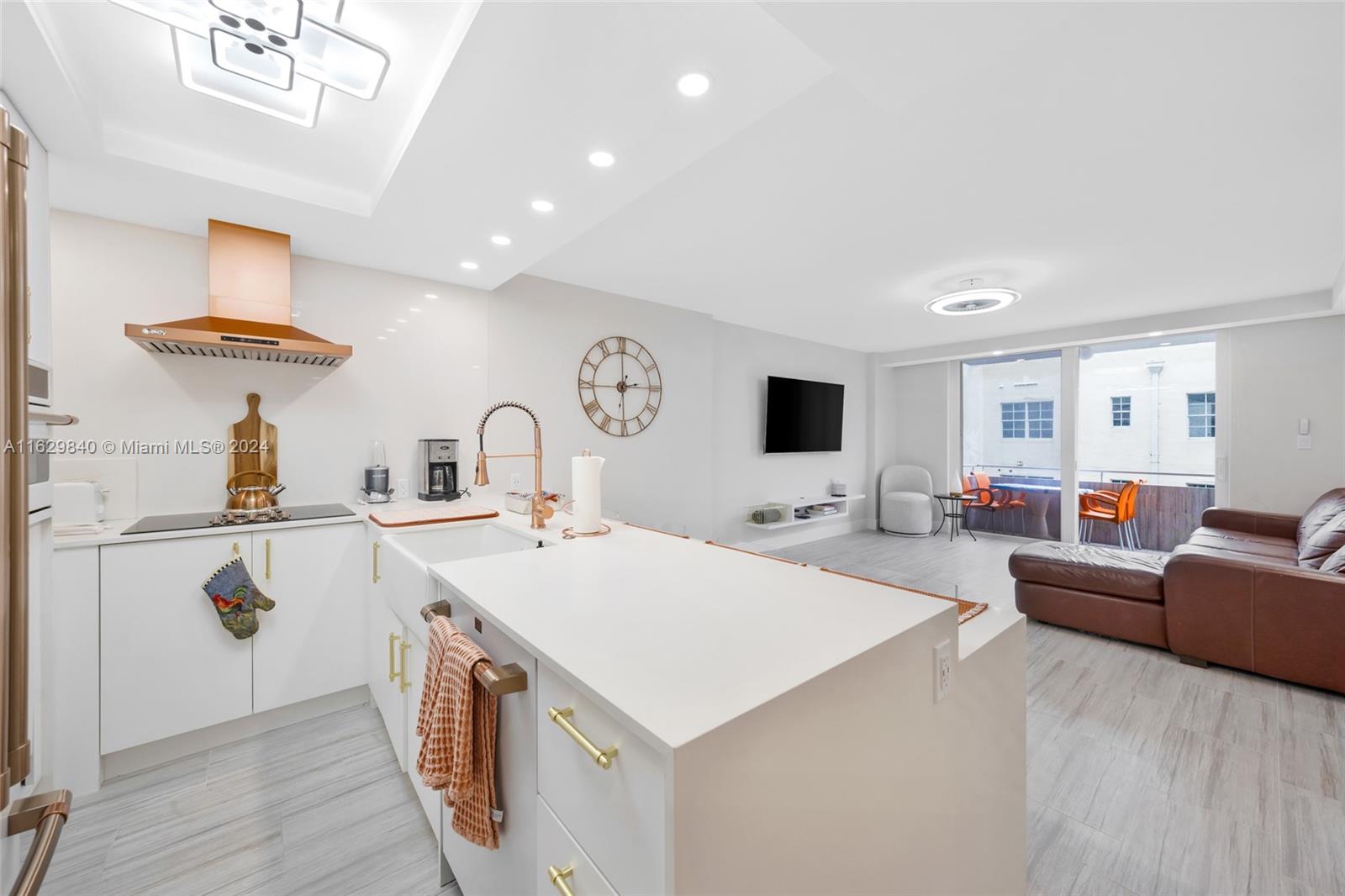 a large white kitchen with a stove a sink a dining table and chairs