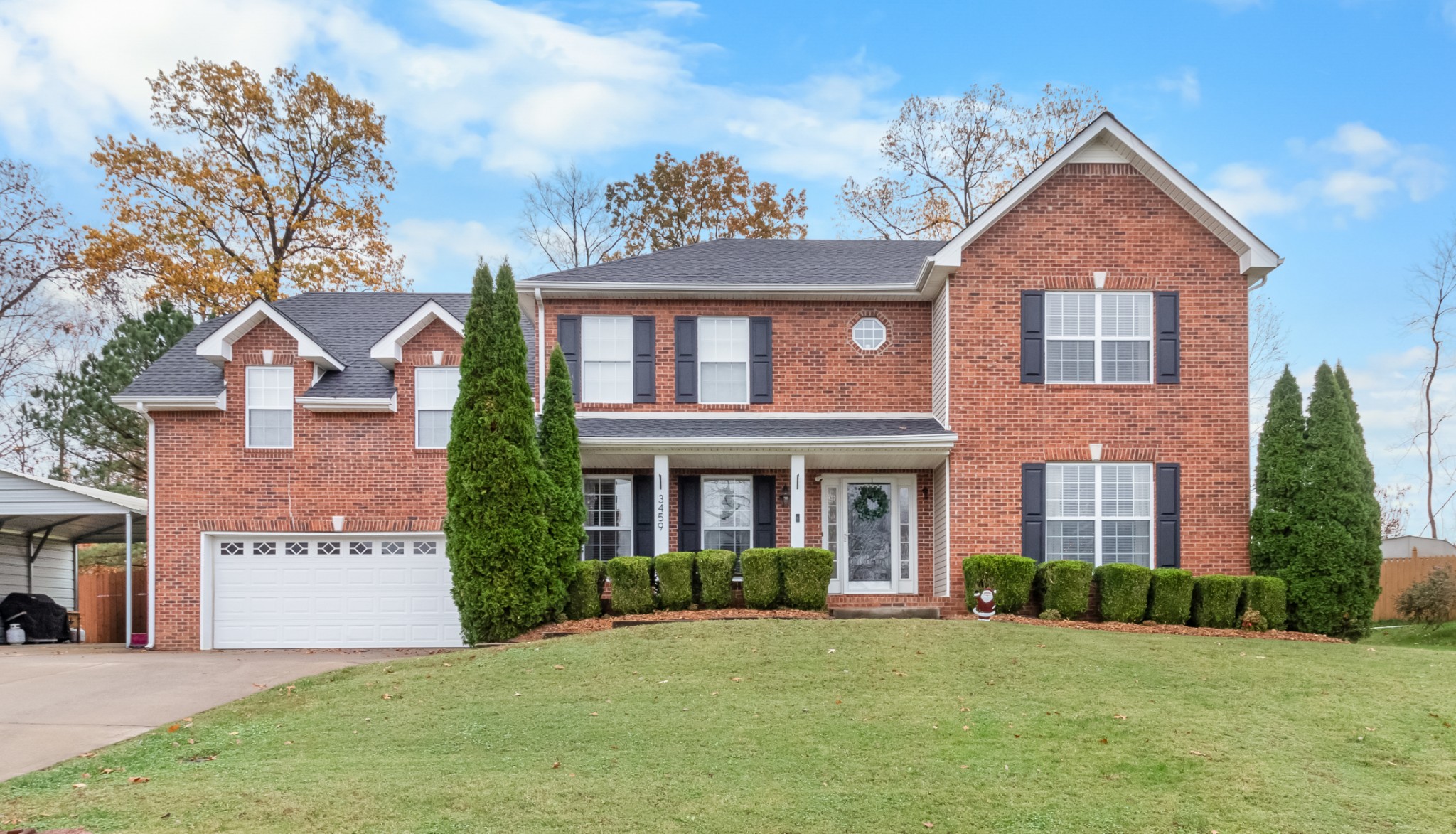 front view of a brick house with a yard