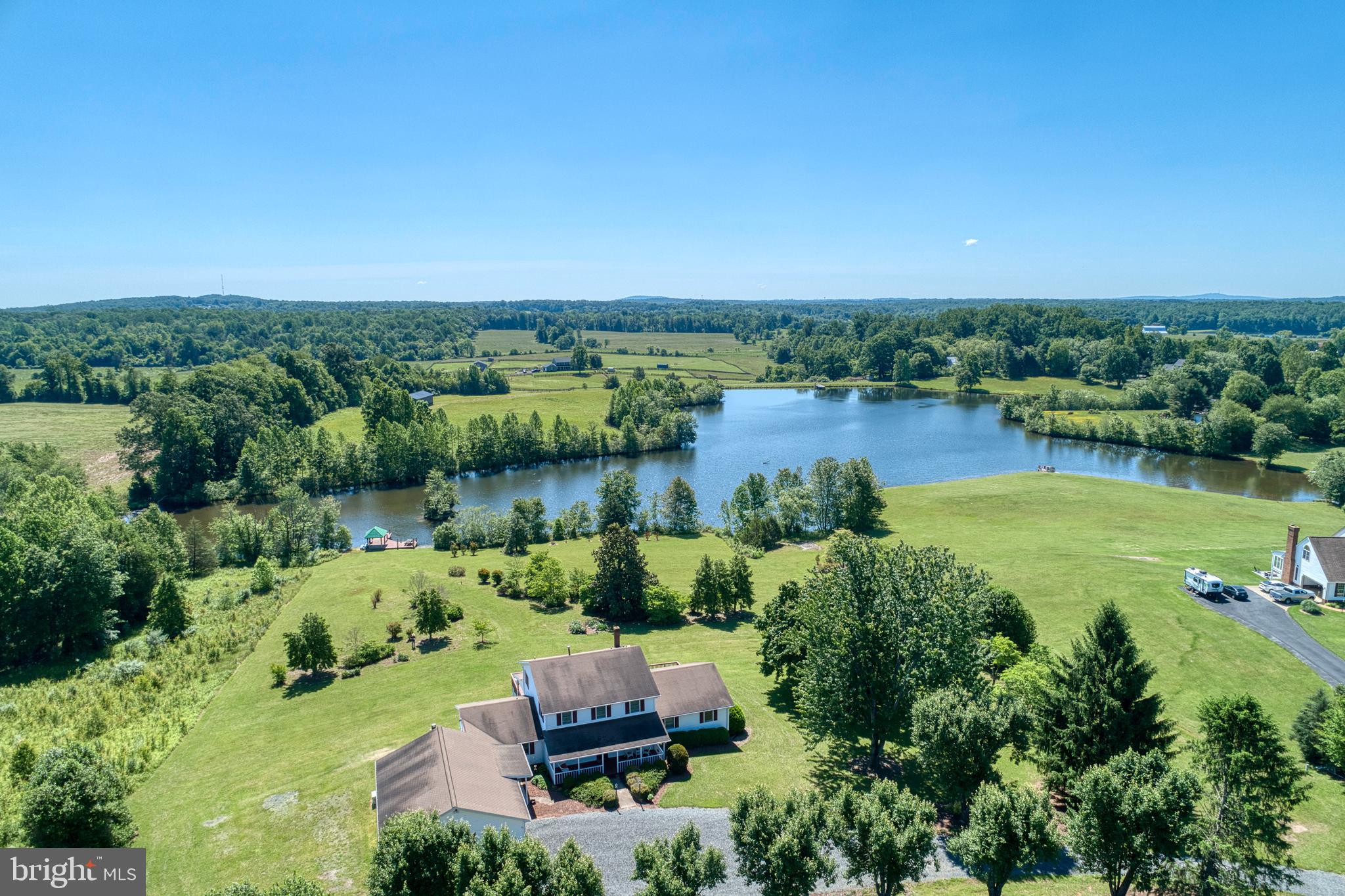 an aerial view of a house with a yard and lake view