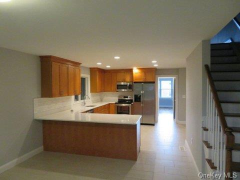 Kitchen featuring kitchen peninsula, appliances with stainless steel finishes, and sink