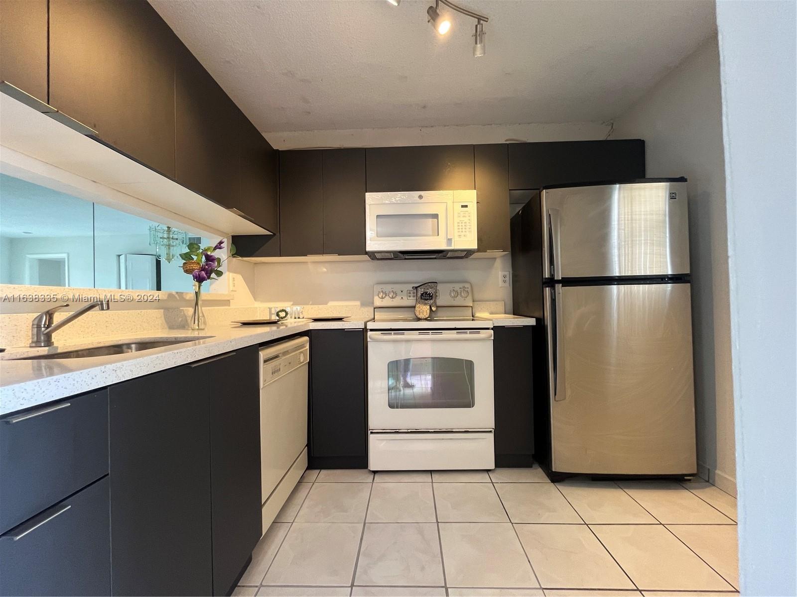 a kitchen with a refrigerator sink and cabinets