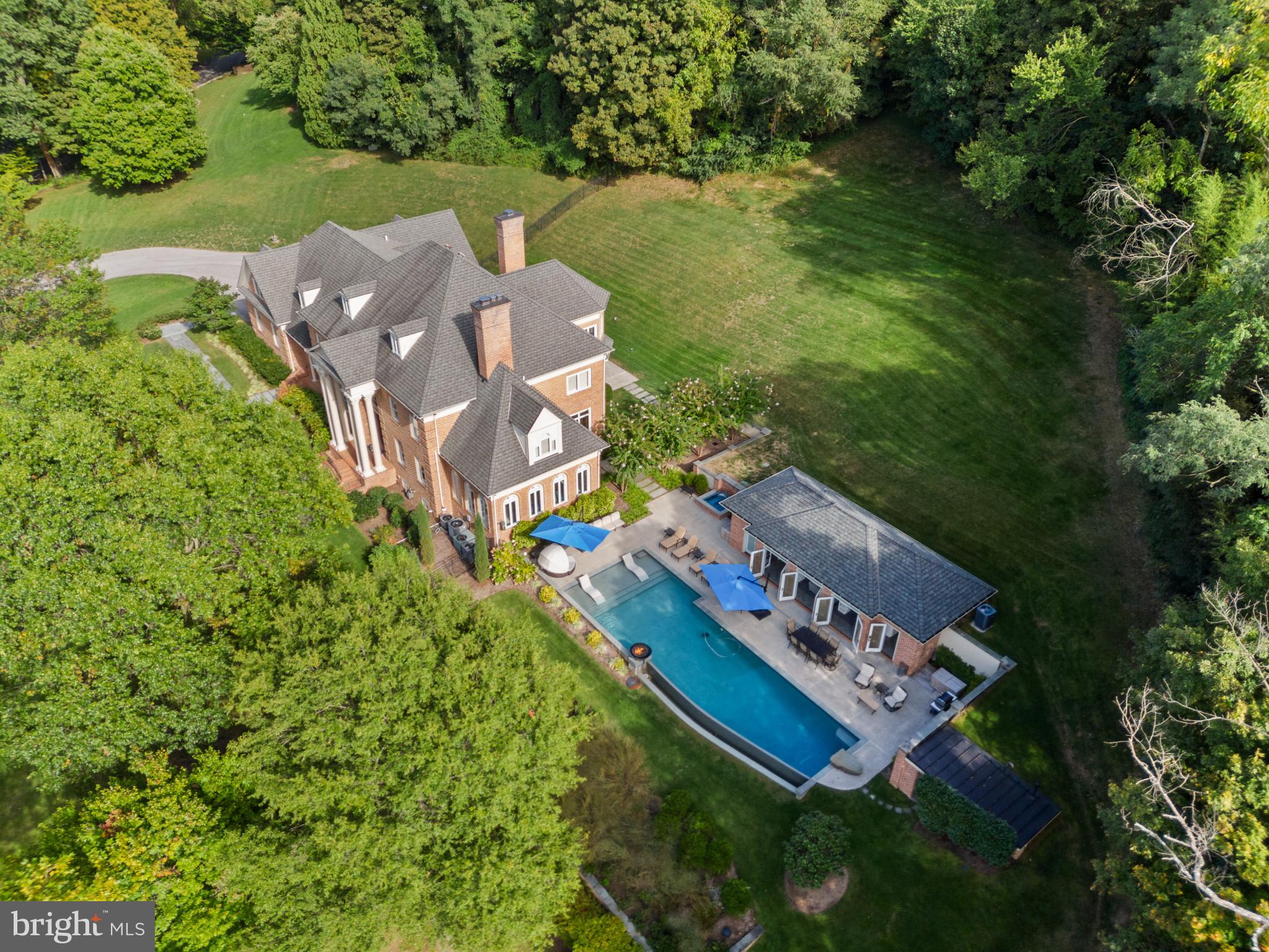 an aerial view of a house with a garden and lake view