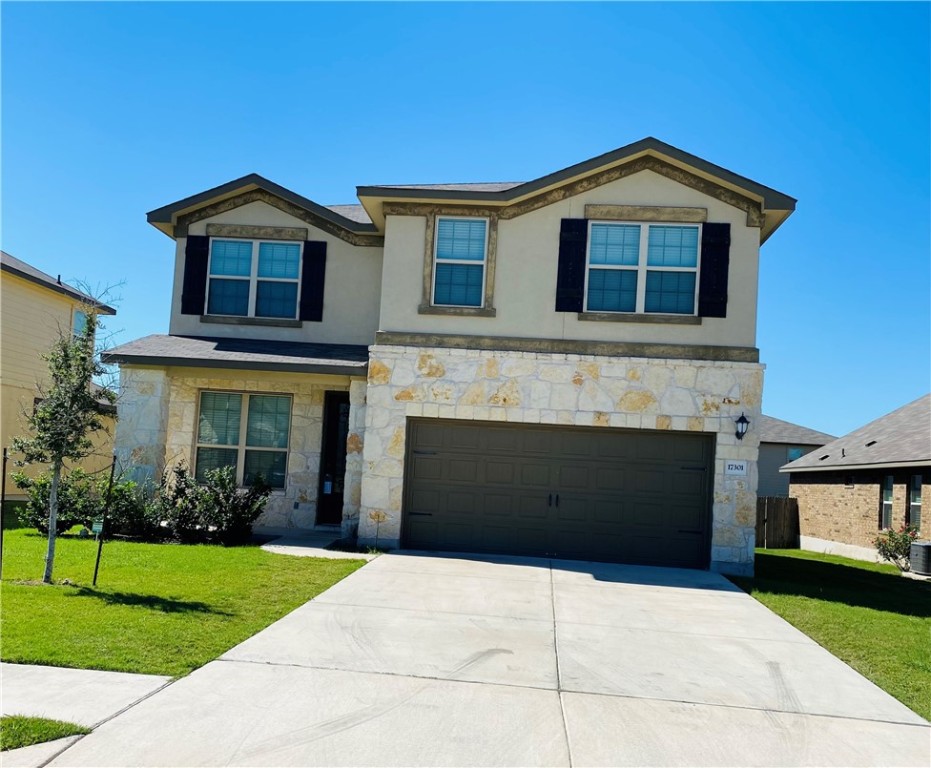 a front view of a house with a yard and garage