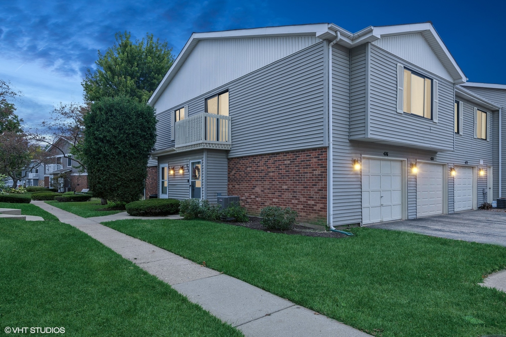 a view of a brick house with a yard and pathway