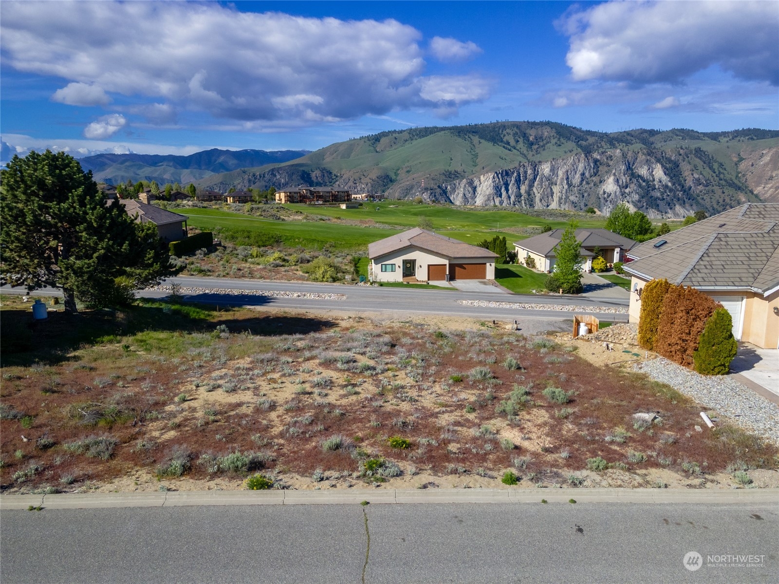 a view of a street with a houses in the background