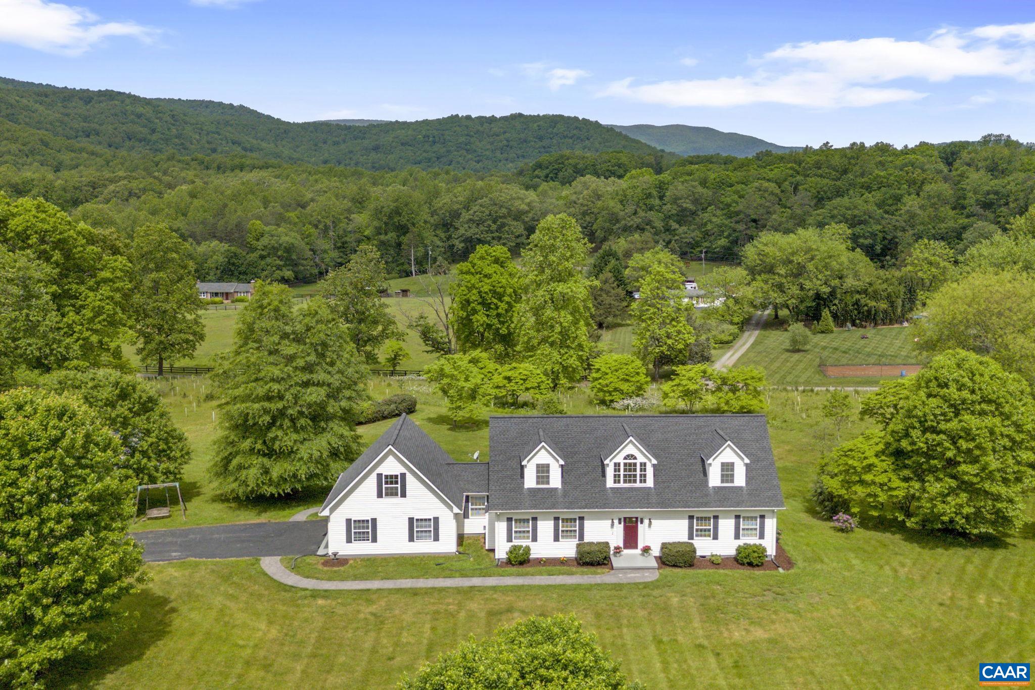 an aerial view of a house with a big yard