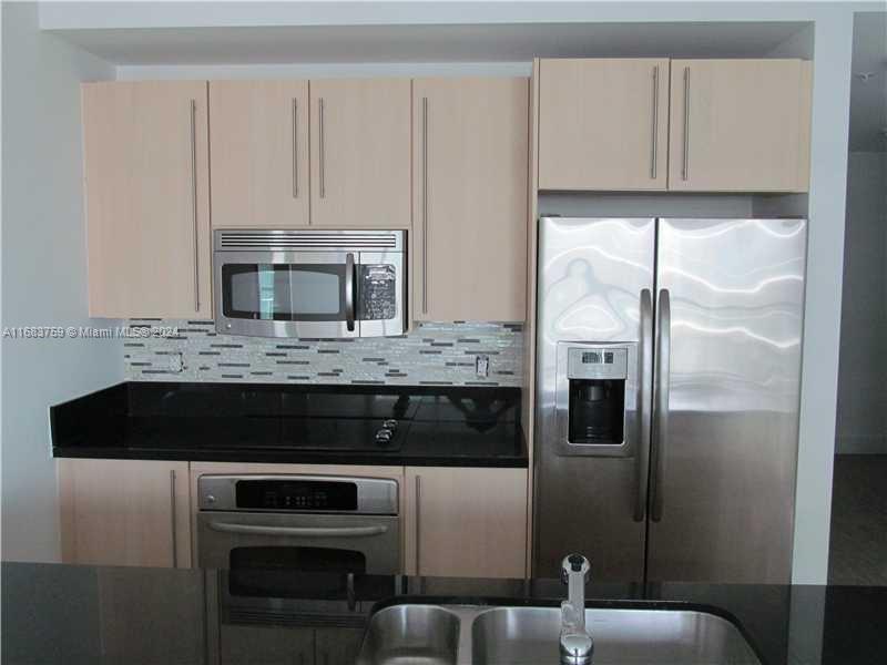 a kitchen with a refrigerator and cabinets