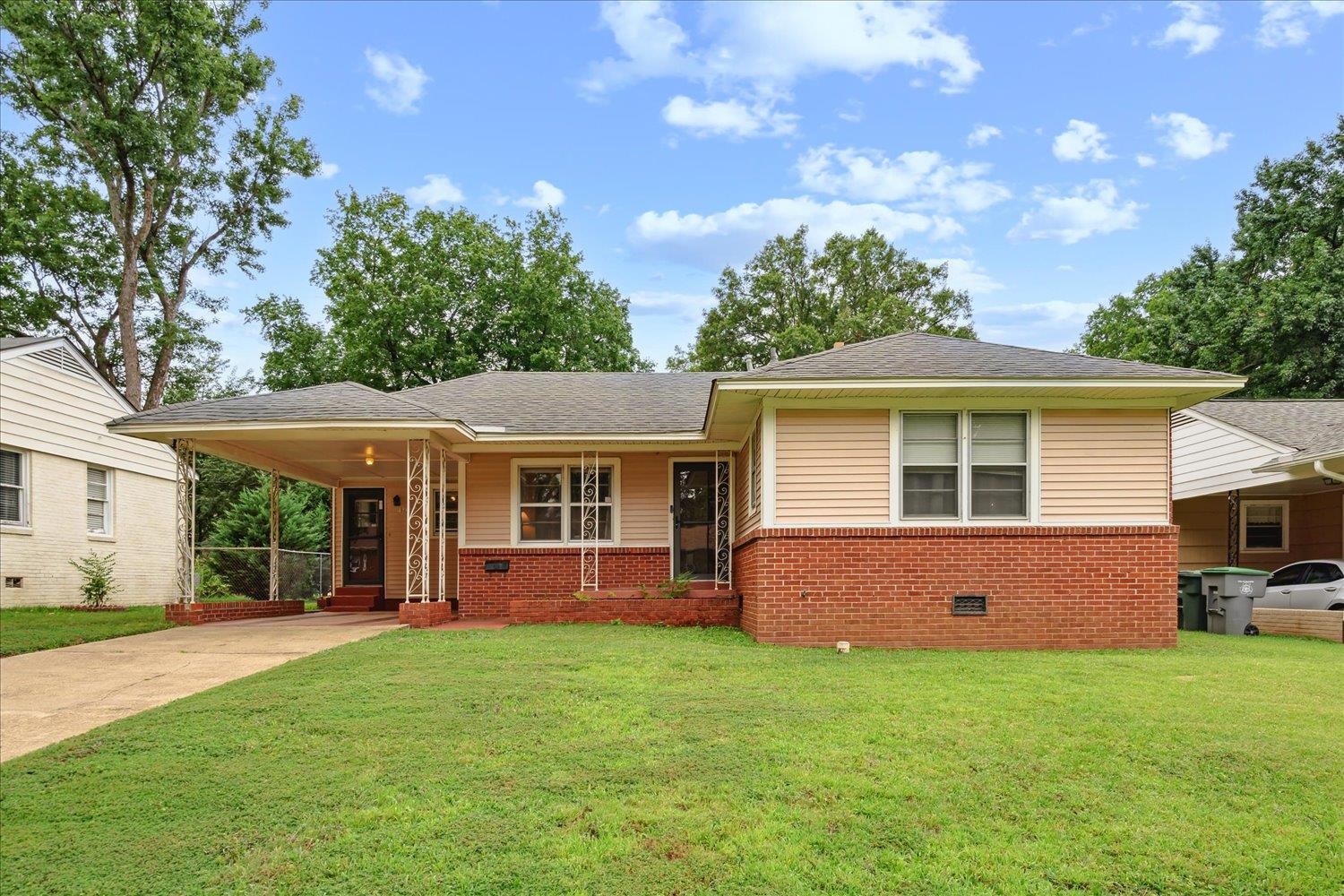 View of front of property featuring a carport and a front lawn