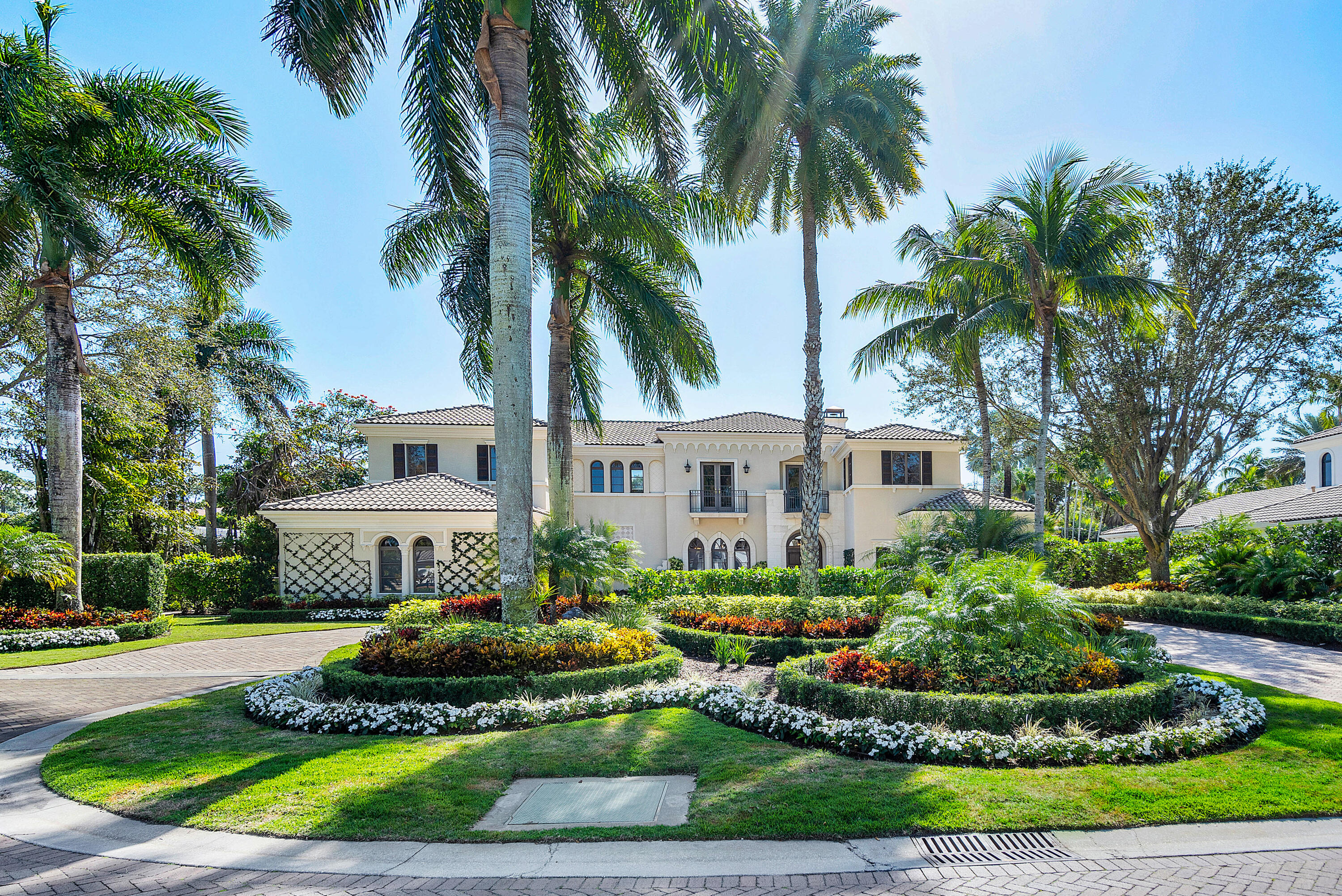 a front view of a house with a garden and trees