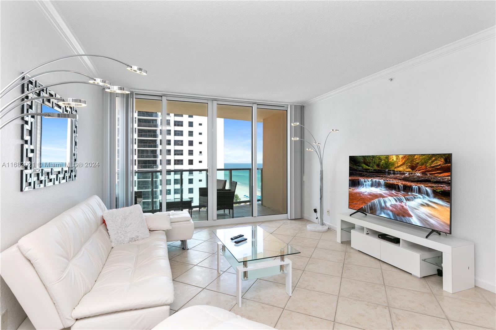 a living room with furniture a flat screen tv and a large window