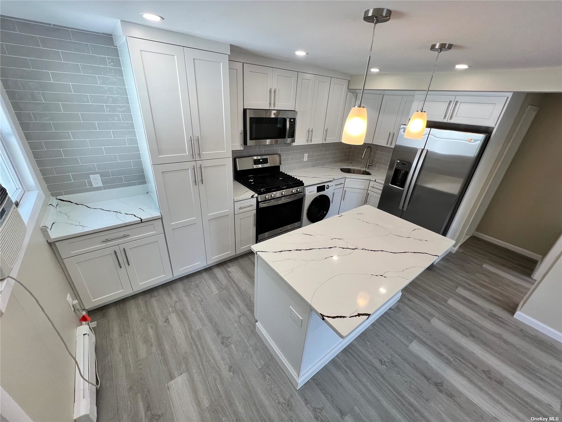 a kitchen with a sink a microwave a stove and refrigerator