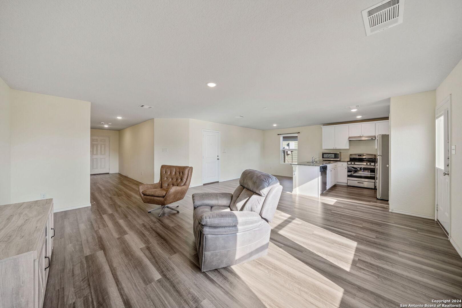 a living room with furniture and a wooden floor