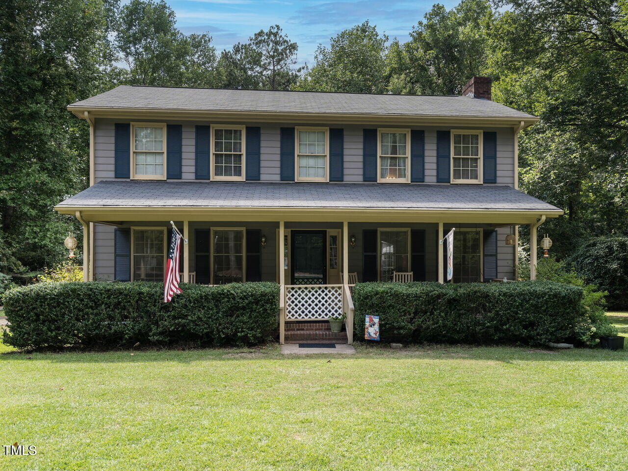 a front view of a house with a yard and trees