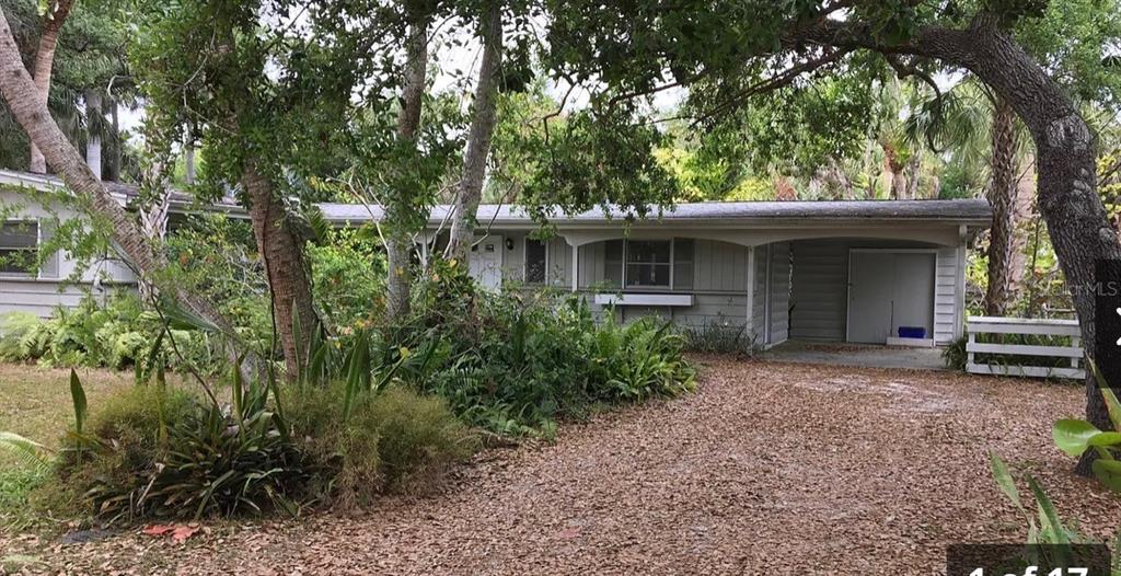 a view of a house with a yard and tree