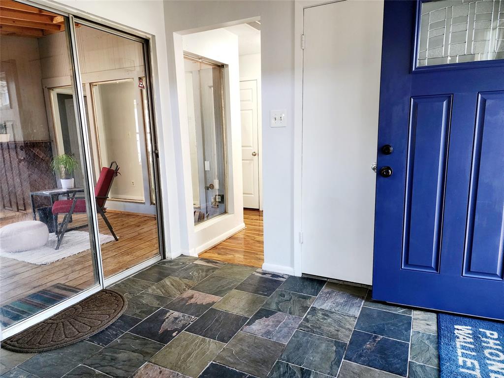 a view of a hallway with wooden floor and glass windows