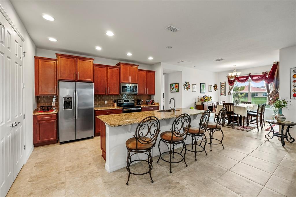 a kitchen with stainless steel appliances granite countertop a refrigerator and a stove top oven