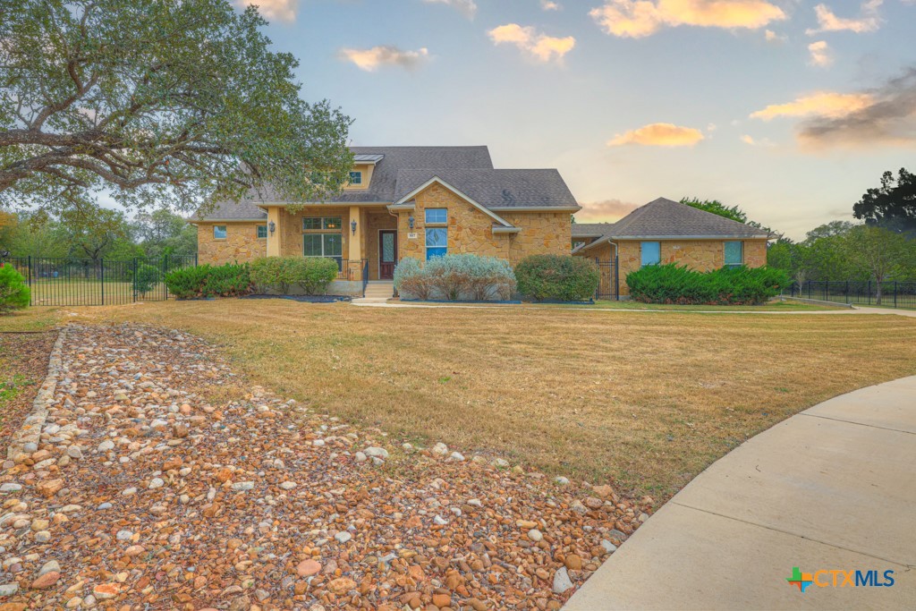 a front view of a house with a yard and mountain view