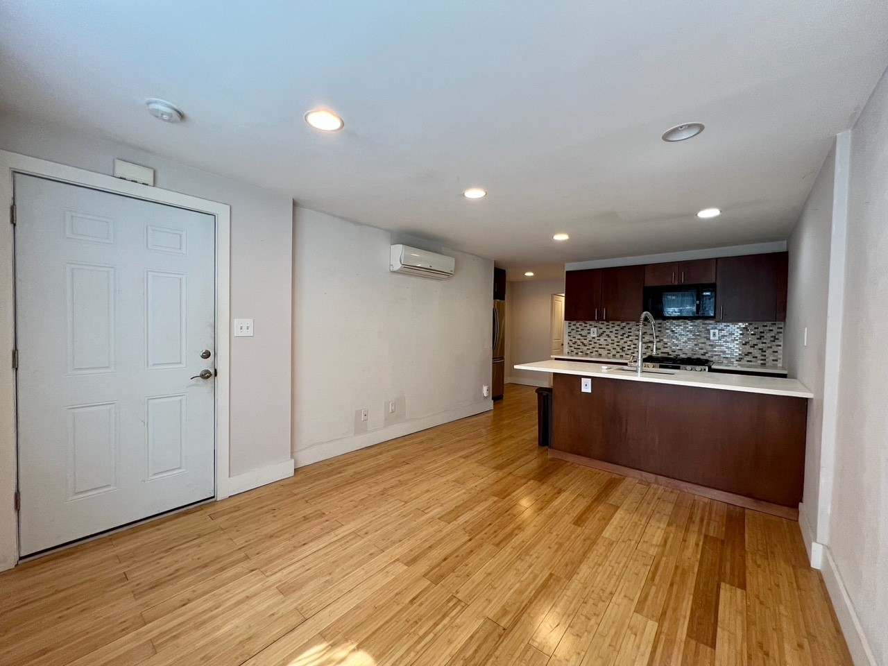 a large kitchen with a lot of counter space and wooden floor