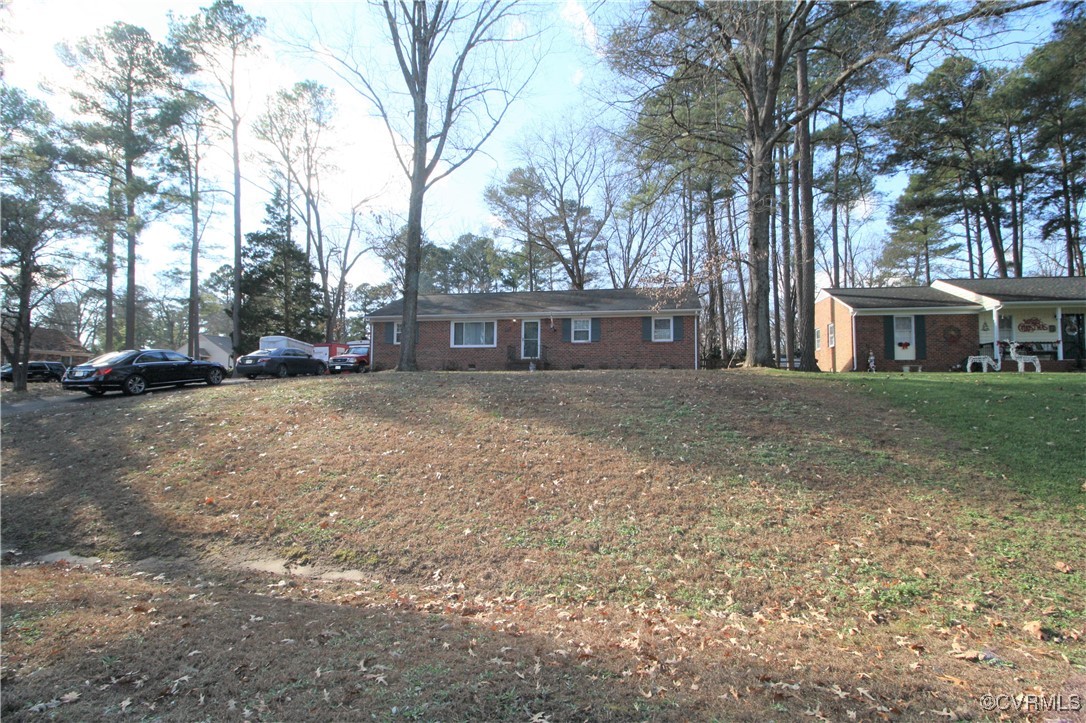 a view of residential houses with yard and trees