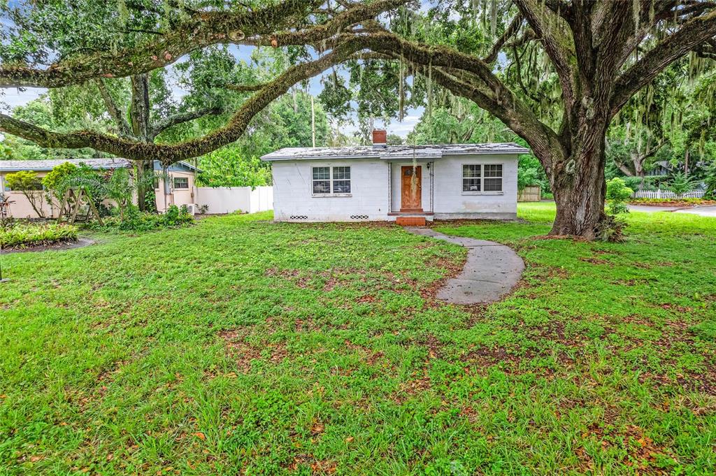 a front view of a house with yard and green space