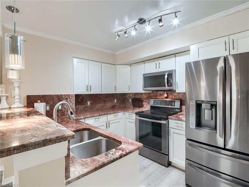 a kitchen with granite countertop a sink stainless steel appliances and counter space