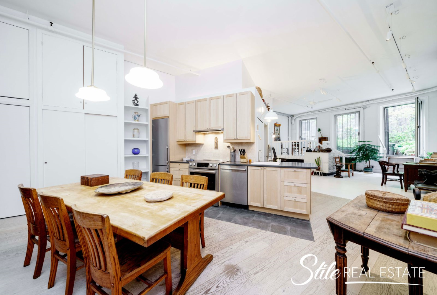 a kitchen with a dining table chairs and white cabinets