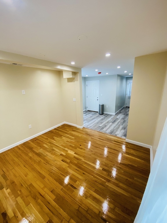 a view of empty room with wooden floor