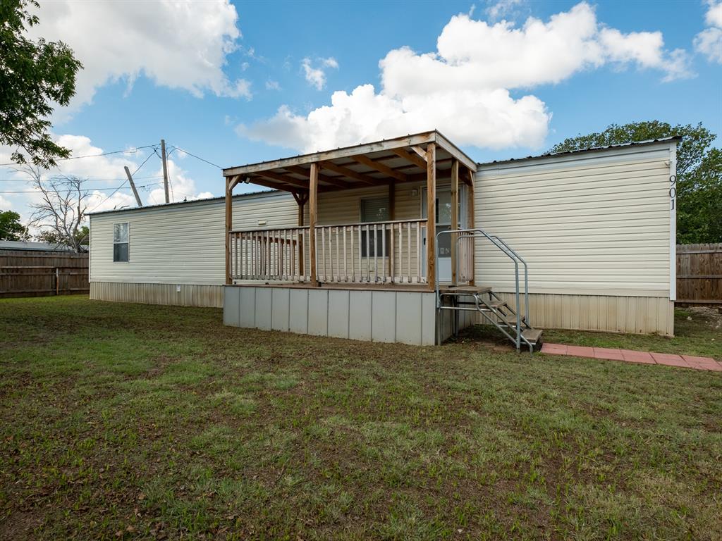 a view of backyard with barbeque grill and wooden fence