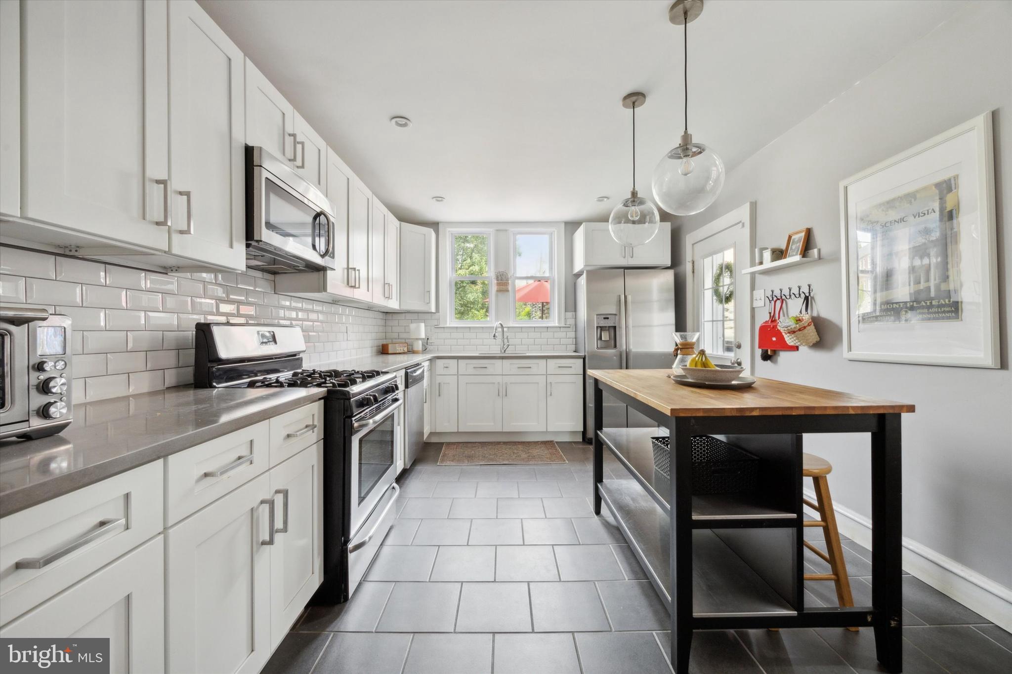 a kitchen with stainless steel appliances granite countertop a sink a stove and a wooden floors