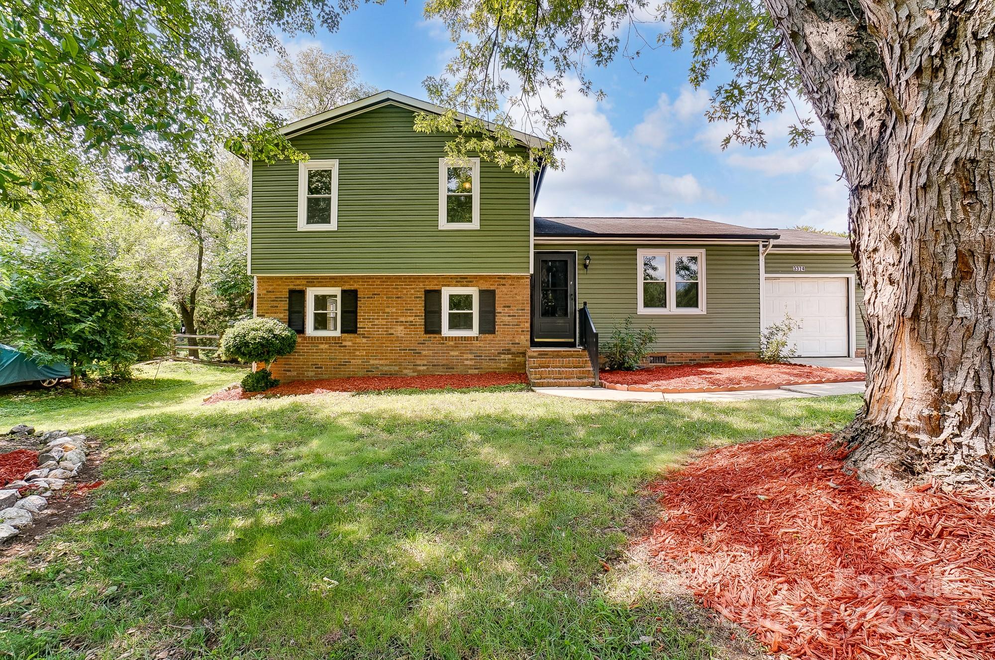 a front view of a house with a yard and trees