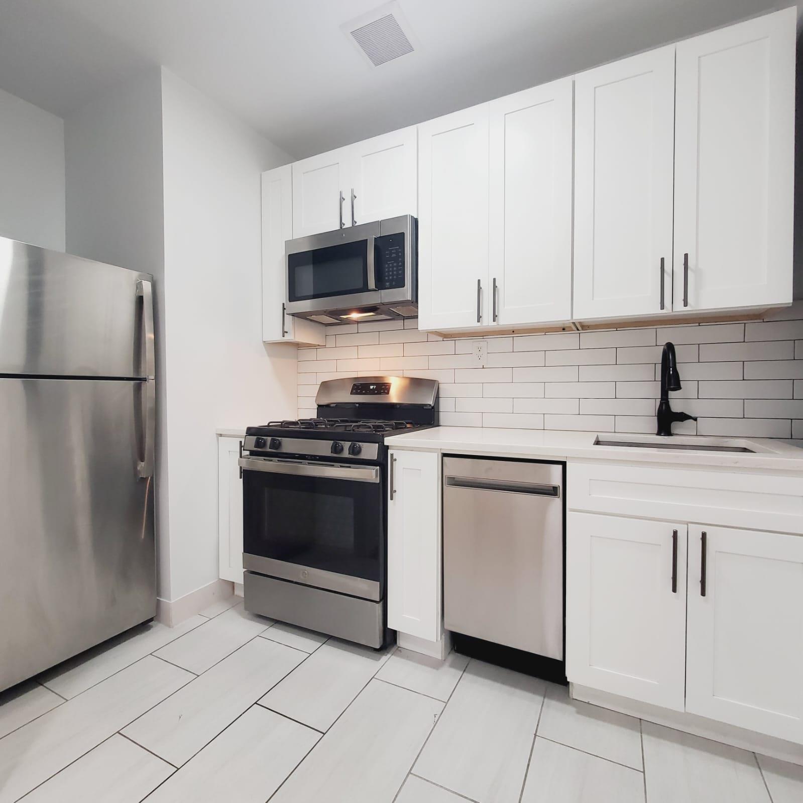 a kitchen with white cabinets and stainless steel appliances