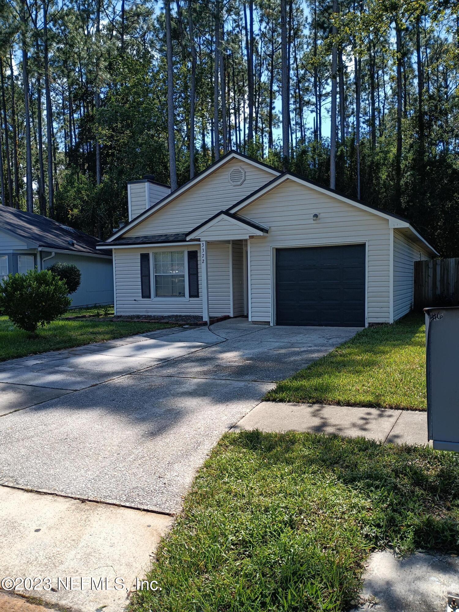 a front view of a house with yard and green space