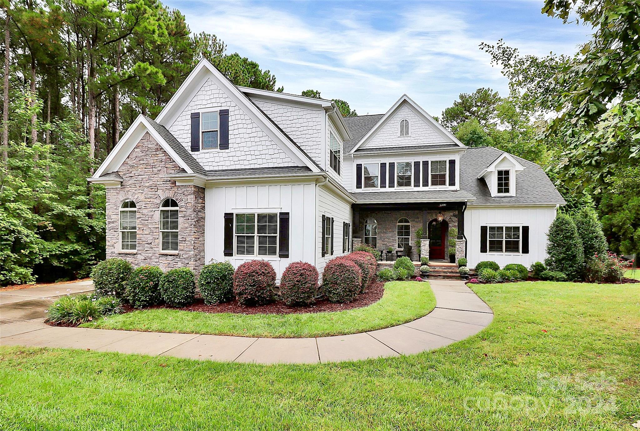 a front view of a house with garden and porch