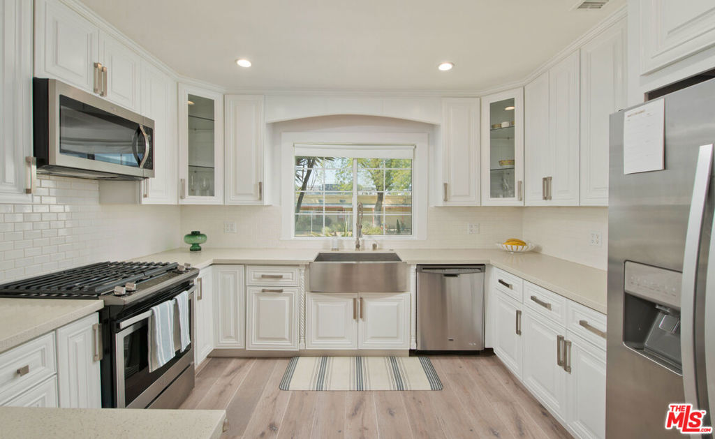 a kitchen with stainless steel appliances a stove a sink and a microwave