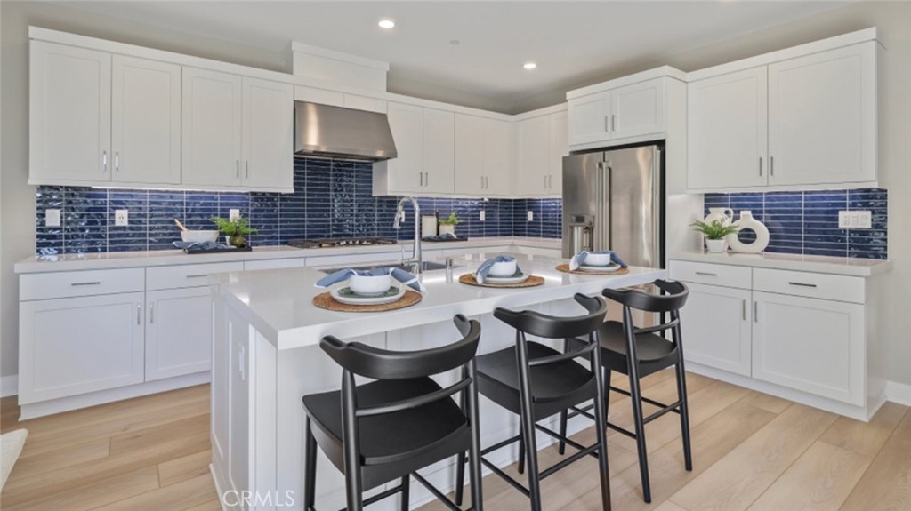 a kitchen with a dining table chairs and white cabinets