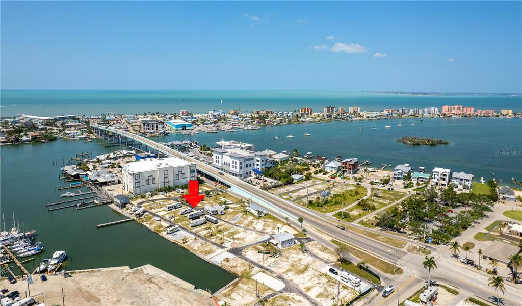 an aerial view of ocean and residential houses with outdoor space