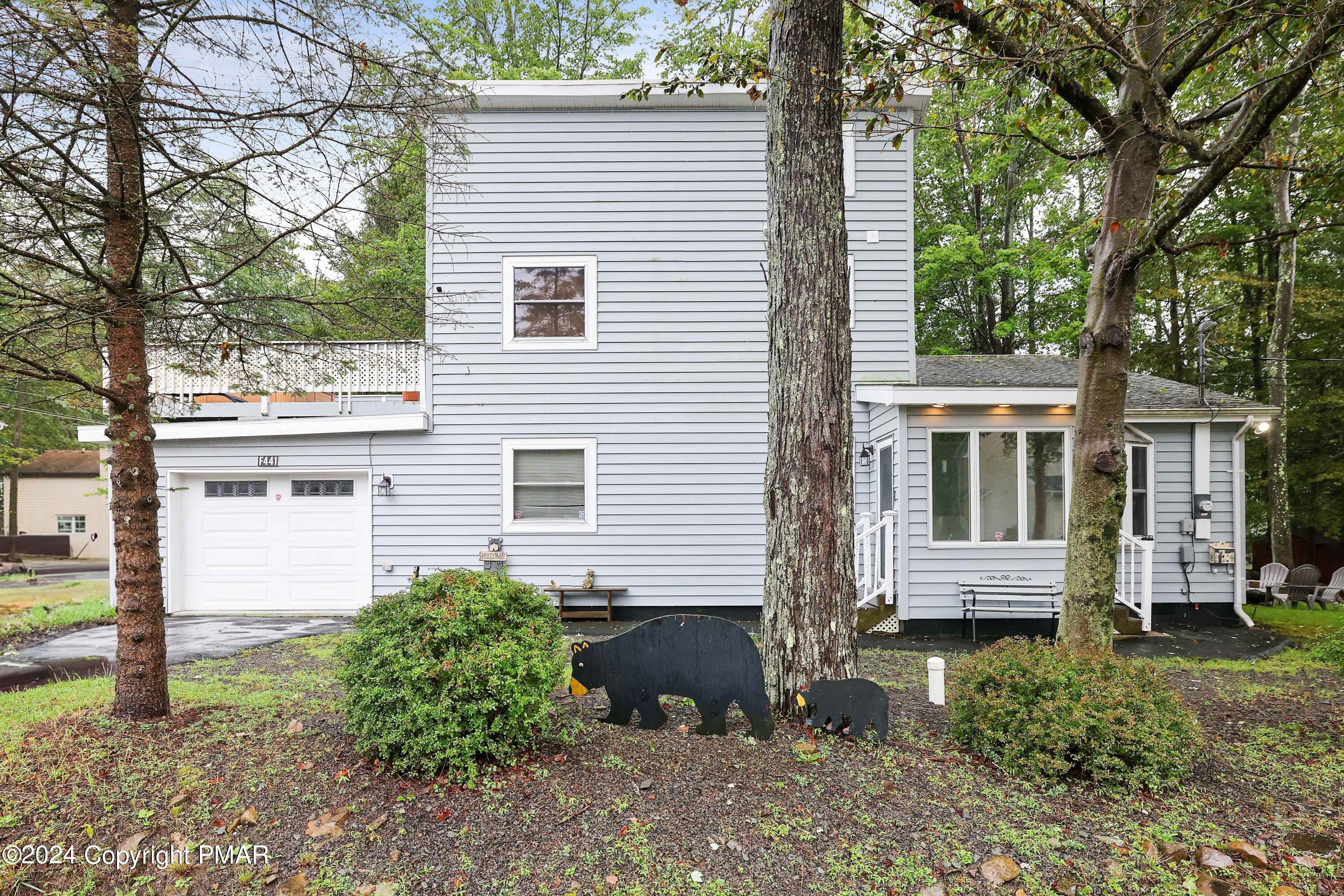 a view of a house with a yard and large tree