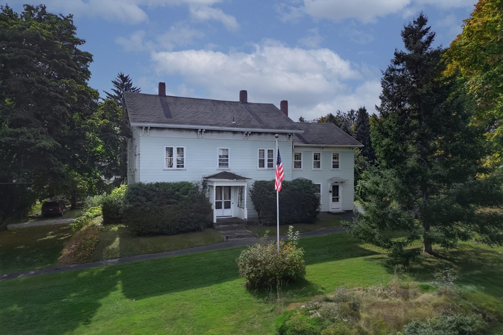 a front view of house with a garden and plants