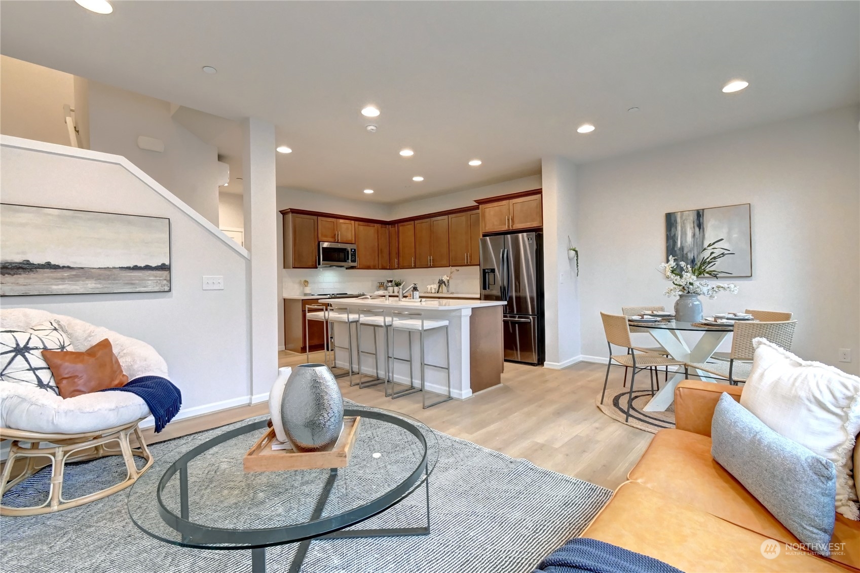 a living room with stainless steel appliances furniture a dining table and kitchen view