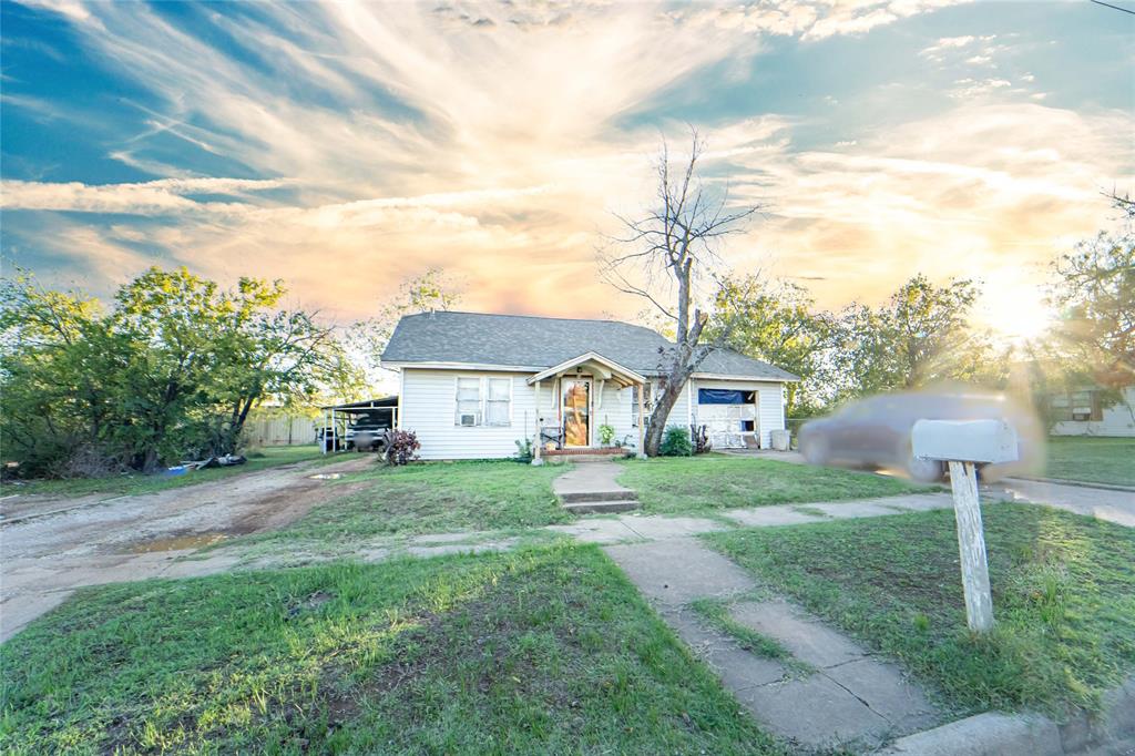 a view of a yard in front of a house with large trees