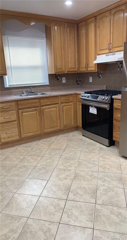 a kitchen with stainless steel appliances granite countertop a stove a sink and a microwave