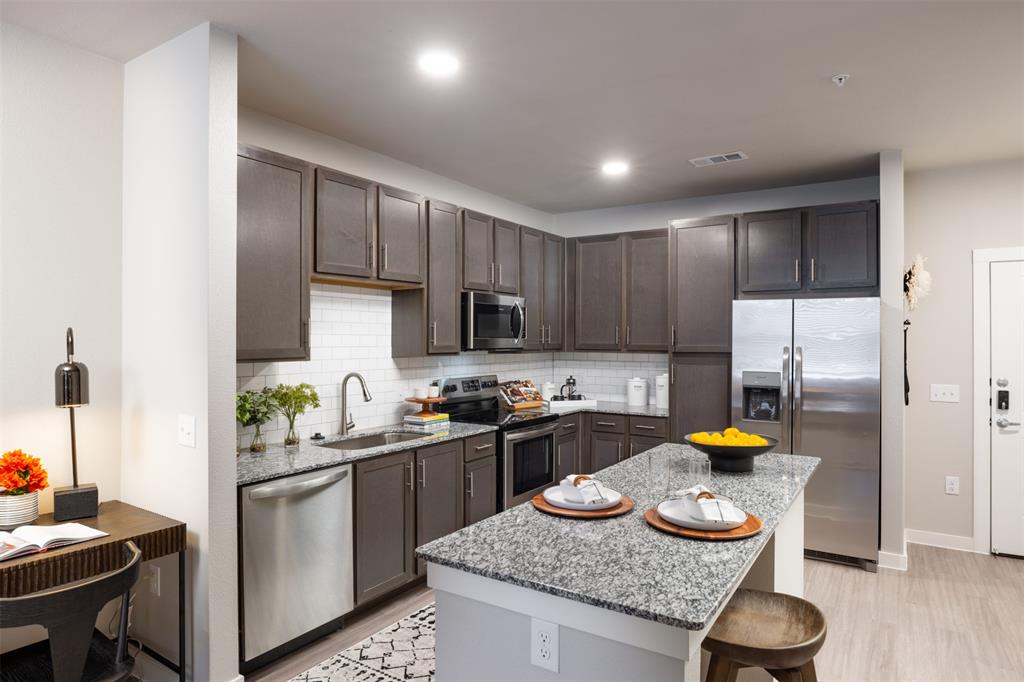 a kitchen with sink refrigerator and stove