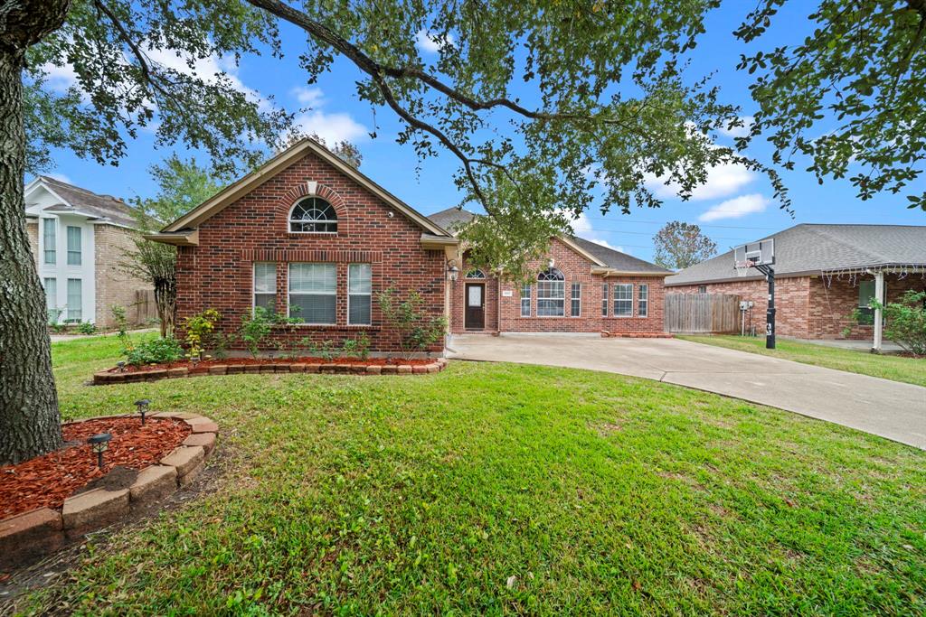 a front view of a house with yard and green space