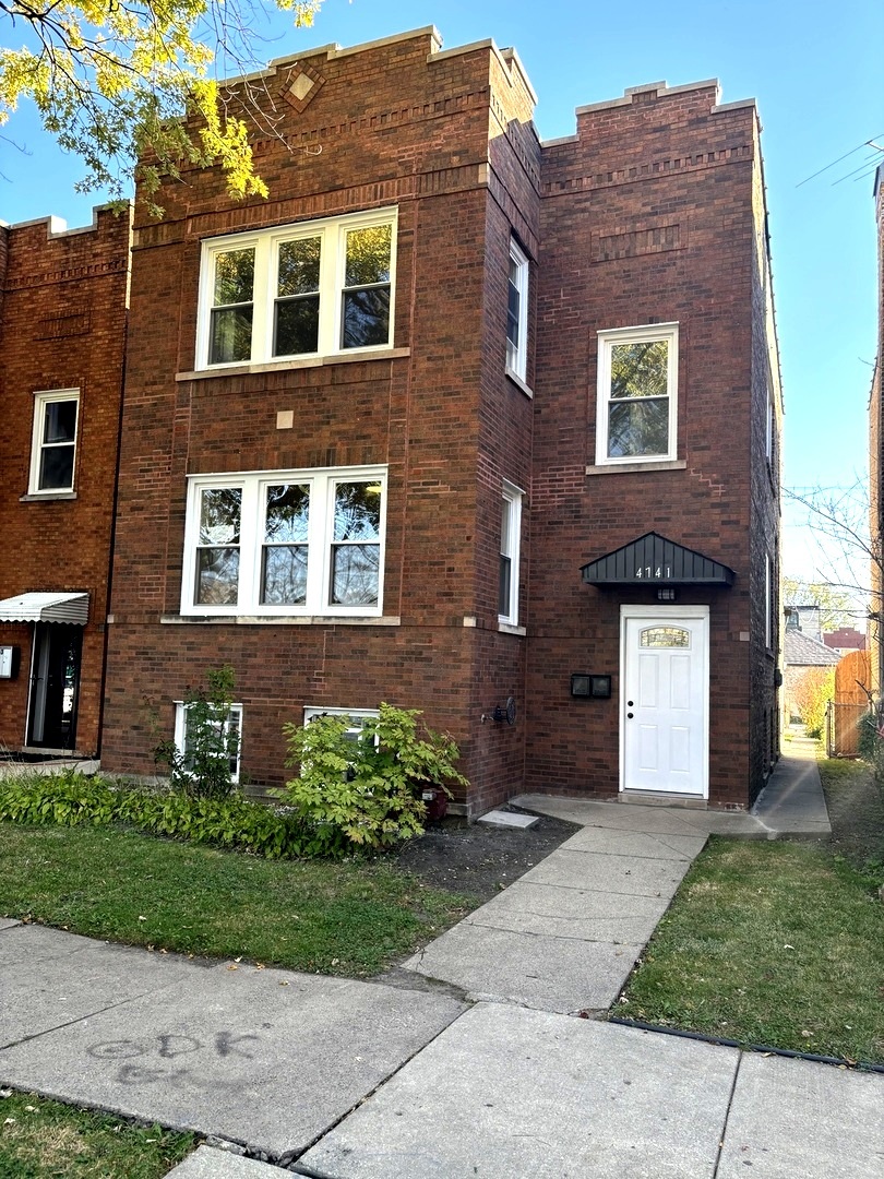 a front view of a house with a garden and plants